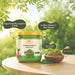 Jar of Rajamudi Moringa Powder with green leaves and a natural background